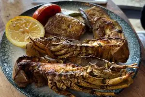 Cavaquinha na brasa aberta ao meio com legumes grelhados e limão