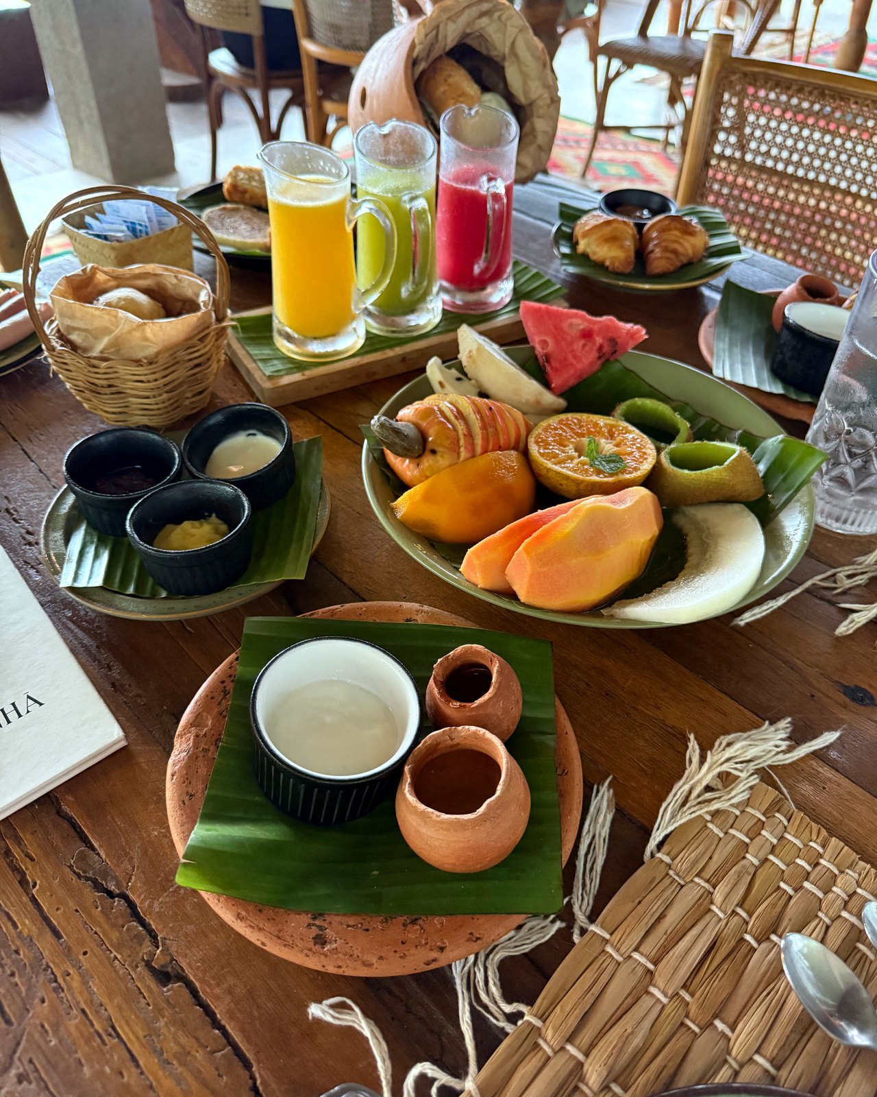 Café da manhã do Zai Patacho servido à mesa: sucos, pães, frutas, croissants, iogurte e mel